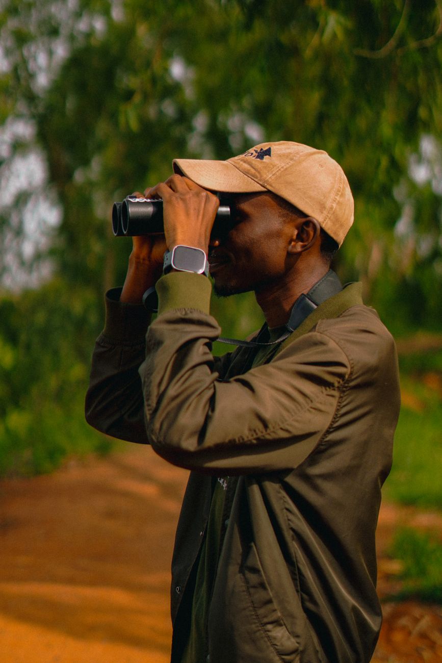 A man enjoys birdwatching outdoors with binoculars in Jos, Nigeria.